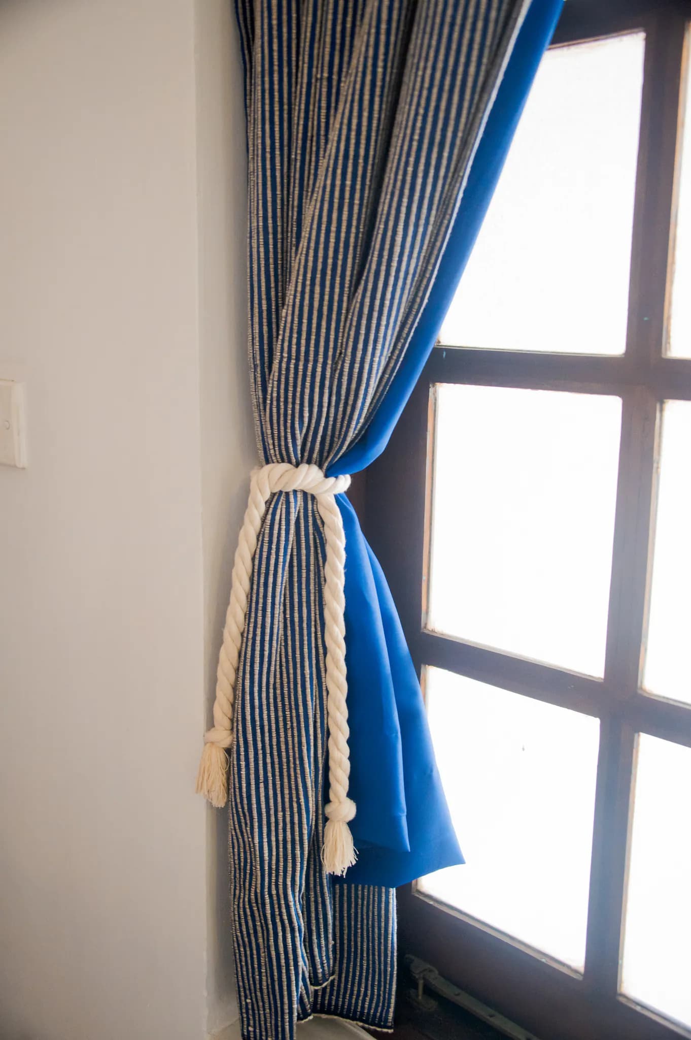 Handloom curtain tied back from a window